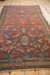 A low perspective on the antique Mehriban rug's textured pile and scrolling floral pattern.