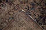 Worn pile and exposed hand-knotted foundation with tattered edge on an antique Kermanshah rug.