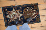 Vintage Heriz rug mat with unique geometric medallion in navy, copper, and pale olive underfoot.