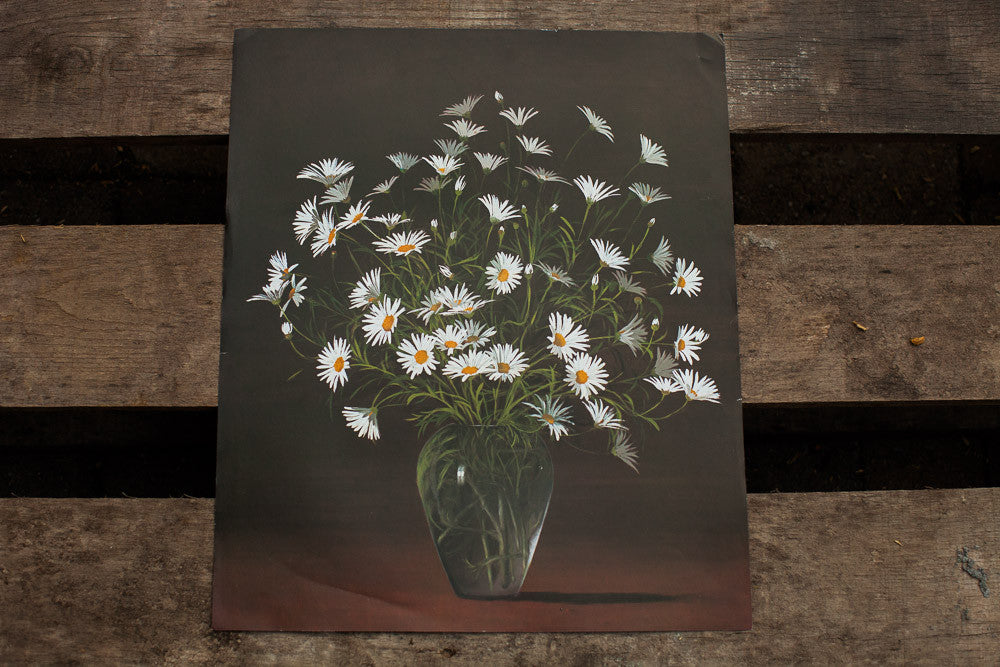 Vintage lithograph of white daisies in a glass vase against a dark background, showing paper creases.
