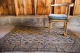 Worn antique Caucasian rug, allover geometric pattern in neutral beige and deep blue.