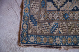 Geometric blue and beige patterns at the worn edge of an antique Caucasian rug.