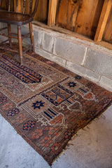 Belouch prayer rug runner with nutty brown field, unique geometric motifs in deep purple and rust.