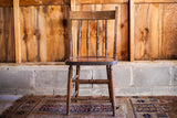 Antique wooden oak chair with four back spindles and rich rustic patina.