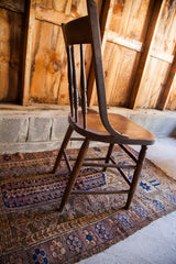 Antique oak chair legs and seat with rustic patina and white paint splatters.