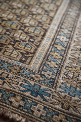Textured hand-knotted pile with earthtone geometric boteh and turquoise border details.