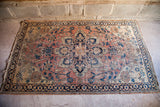Unique coral and blue floral corner of antique Dorokhsh rug with worn pile.