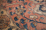 Worn antique Dorokhsh rug close-up, unique blanched terracotta and blue vine motifs.