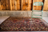 Worn geometric tribal rug with red, blue, and brown patterns, 3'11