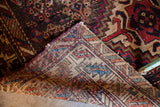 Folded corner of a late 19th century tribal geometric rug, revealing hand-knotted foundation.