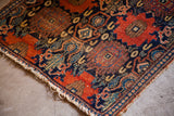 Persian Senneh rug with heavy tattered ends, showcasing intricate border and field patterns.