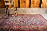 Antique Kerman rug, worn cochineal red, ivory tones, with Safavid inspired border design.