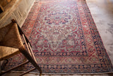 Antique Kerman rug's fringed end, Safavid-inspired border, with worn cochineal red and dark blue.