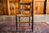 Primitive 19th century antique rush seat chair with dark wood and aged patina.