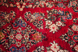 Tightly knotted red Sarouk pile showcasing intricate cream, blue, and black floral motifs.