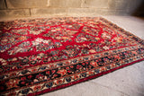 Red American Sarouk runner with intricate floral motifs and tightly wrapped black/dark blue selvage.
