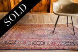 Aged pile texture on a late 19th century Kerman rug's classic floral design.