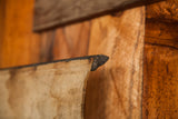 Aged canvas edge of an antique map, showing dark wooden dowel and historic patina.