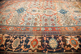 Angled perspective on the intricate, multi-layered borders of an antique Farahan Sarouk rug.