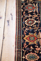 Detail of the antique Farahan Sarouk's intricate border with herati motifs on a dark blue ground.