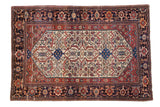 Antique Farahan Sarouk rug featuring herati and samovar motifs on an ivory ground with dark, floral borders.