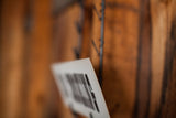 Blurred view of a vintage sign's textured white edge and faint black marks against warm brown.