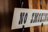 Angled view of a light beige vintage 'NO' sign with bold black lettering.
