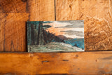 Lower right portion of the vintage ink landscape showing blue water and warm sunset sky.