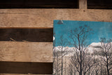 Peeling paper detail on the corner of the lithograph's deep teal sky.