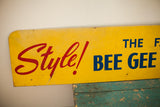 Mid Century Bee Gee advertising sign with blue lettering on yellow, showing peeling paint.