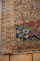 Corner of an antique Farahan rug showing the soft wool pile, detailed border, and time-softened contouring.