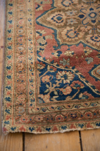 Corner of an antique Farahan rug showing the soft wool pile, detailed border, and time-softened contouring.