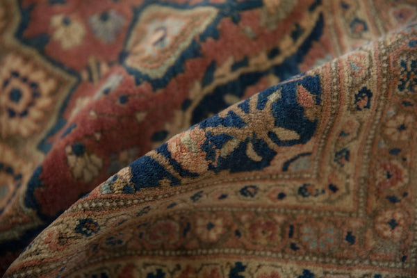 A soft fold reveals the plush, dense wool of a collector-quality antique Farahan Sarouk rug.