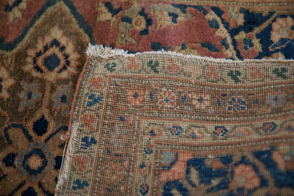 Folded corner of a collector Farahan rug revealing the fine hand-knotted foundation and soft wool pile.