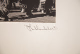 Artist's signature below black and white Native American dance ceremony photograph.