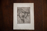 Greyscale etching close-up showing the man's almond eyes, expressive face, and hat.