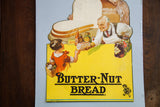 Vintage Butter-Nut Bread poster with a die-cut top featuring a smiling grocer and a girl.