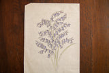 Antique watercolor of blue bell flowers and celadon stems on aged, creased paper.