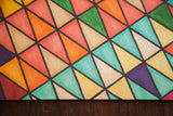 Detail of textured card stock with vibrant geometric triangles in yellow, red, aqua, and purple.