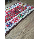 Colorful geometric patterns and flatweave texture along the border of a vintage Turkish Kilim.