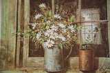 White daisies in a weathered tin pitcher on a rustic wooden windowsill.