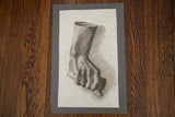 Antique charcoal sketch by Elizabeth Pease of a closed fist mounted on grey cardstock.