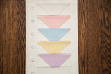 Numbered pastel fabric swatches with serrated edges on an antique sampler art card.