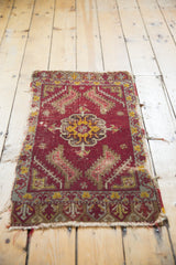 Antique Turkish mat, showing tattered right edge and geometric red and gold medallion.