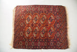 Geometric Tekke rug guls in madder red, aubergine, dark blue, and ivory.