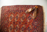 Vintage Tekke rug with madder red field, geometric guls in aubergine, blue, and ivory.