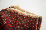 Tekke rug corner: madder red, aubergine geometric pattern, worn fringe, flat weave kilim.