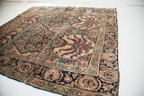 Dark patterned border and expressive red leaf motifs on antique Kerman rug.