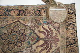 Expressive leafy design in deep purple, blue, and ivory on antique Persian Kerman rug.
