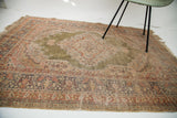 Worn green field, intricate traditional border, and original fringe on a vintage Turkish rug.